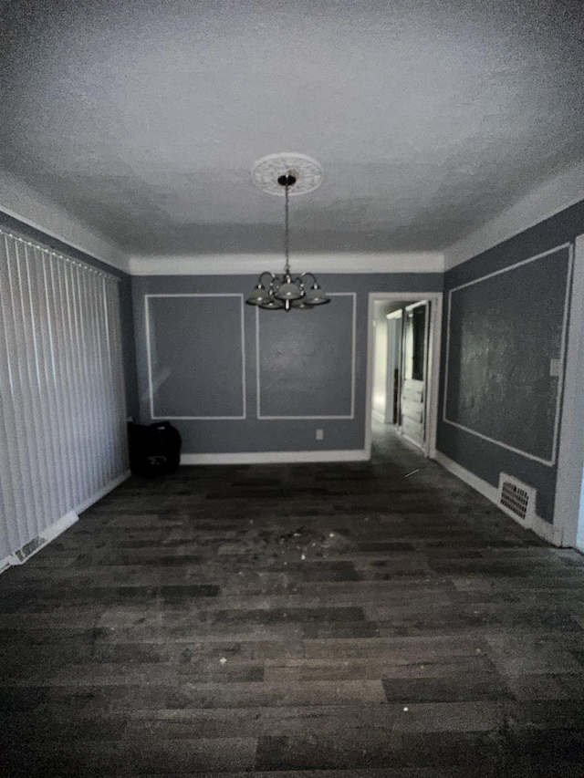 15043 Holmur St, Detroit, MI 48238 - unfurnished dining area with a textured ceiling, wood finished floors, and a chandelier
