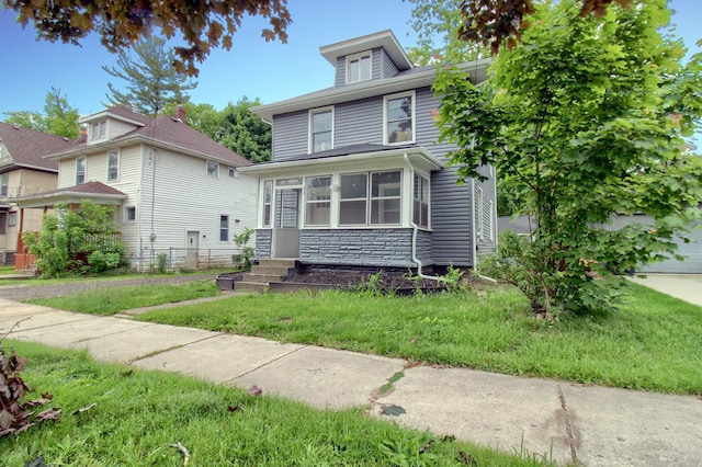 609 W Biddle St, Jackson, MI 49203 - traditional style home with stone siding, a front lawn, and entry steps