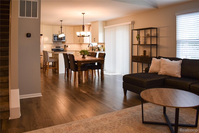 18006 Wingate Dr, Macomb, MI 48042 - living room featuring a chandelier and dark wood-style flooring