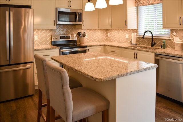 18006 Wingate Dr, Macomb, MI 48042 - kitchen featuring appliances with stainless steel finishes, dark wood finished floors, backsplash, a kitchen island, and light stone counters