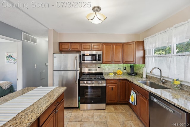 29934 Tamarack Dr, Gibraltar, MI 48134 - kitchen with appliances with stainless steel finishes, light stone countertops, decorative backsplash, and brown cabinetry