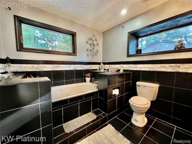 7135 Gardner Line Rd, Lexington, MI 48450 - bathroom featuring a tub with jets, tile patterned floors, tile walls, and wainscoting