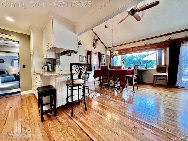 7135 Gardner Line Rd, Lexington, MI 48450 - kitchen with white cabinetry, a ceiling fan, vaulted ceiling, light wood finished floors, and crown molding