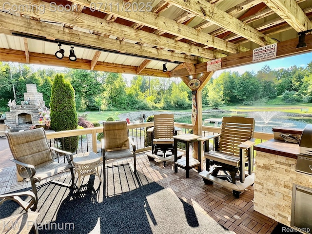 7135 Gardner Line Rd, Lexington, MI 48450 - view of patio with an outdoor stone fireplace, view of scattered trees, area for grilling, and a water view