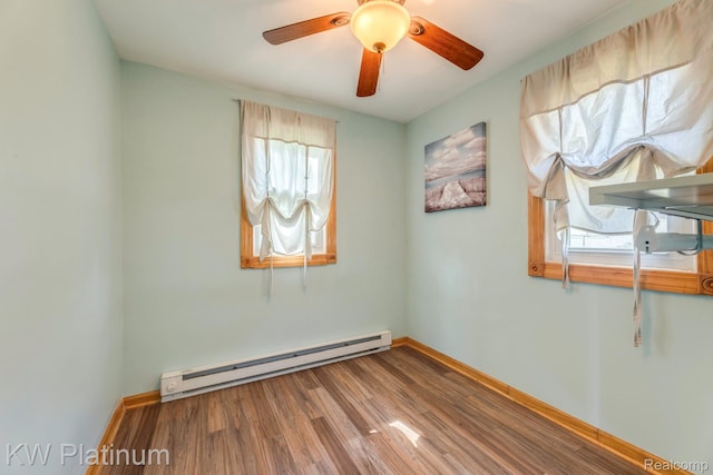 7377 Dogwood Rd, Lexington, MI 48450 - unfurnished room with a baseboard radiator, wood finished floors, and a ceiling fan