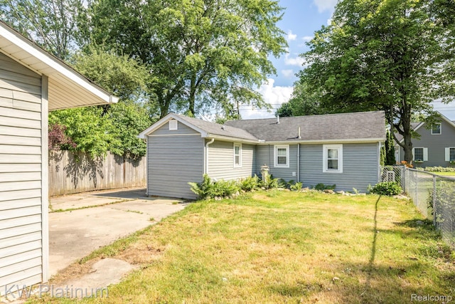 7377 Dogwood Rd, Lexington, MI 48450 - rear view of house with a fenced backyard, a patio area, a chimney, and a shingled roof
