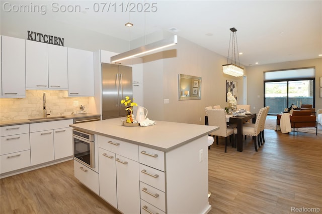 750 Forest Ave Unit 202, Birmingham, MI 48009 - kitchen with stainless steel built in refrigerator, light wood-style flooring, tasteful backsplash, a center island, and white cabinets