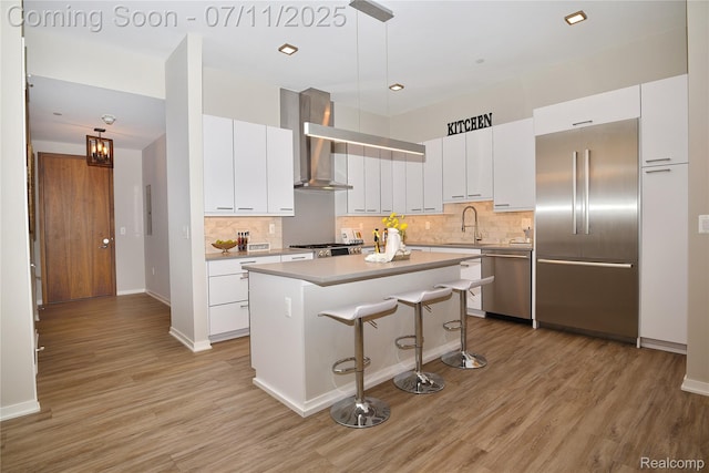 750 Forest Ave Unit 202, Birmingham, MI 48009 - kitchen featuring stainless steel appliances, wall chimney exhaust hood, light wood finished floors, a breakfast bar, and recessed lighting