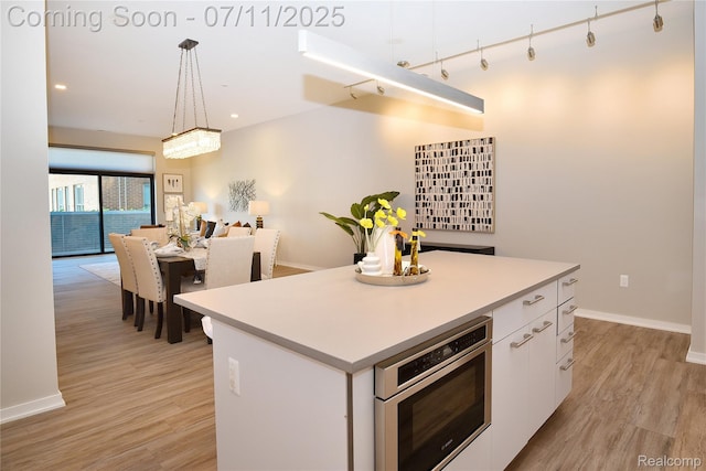 750 Forest Ave Unit 202, Birmingham, MI 48009 - kitchen featuring white cabinets, light wood finished floors, a center island, light countertops, and recessed lighting