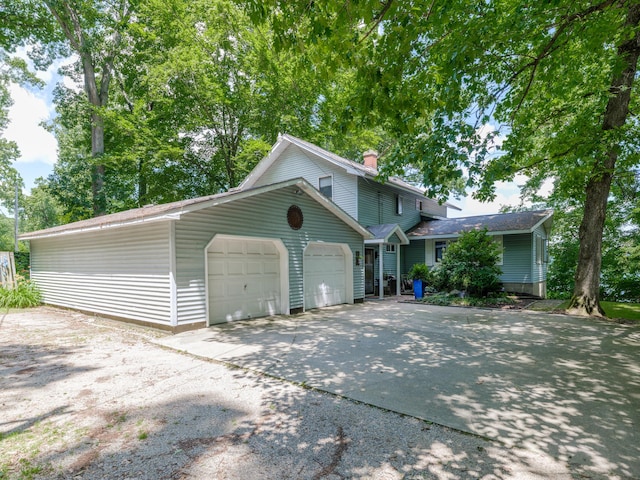 44850 Woodman Dr, Paw Paw, MI 49079 - view of front facade with a chimney, driveway, and an attached garage