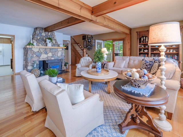 44850 Woodman Dr, Paw Paw, MI 49079 - living room featuring beam ceiling, stairway, wood finished floors, and a stone fireplace