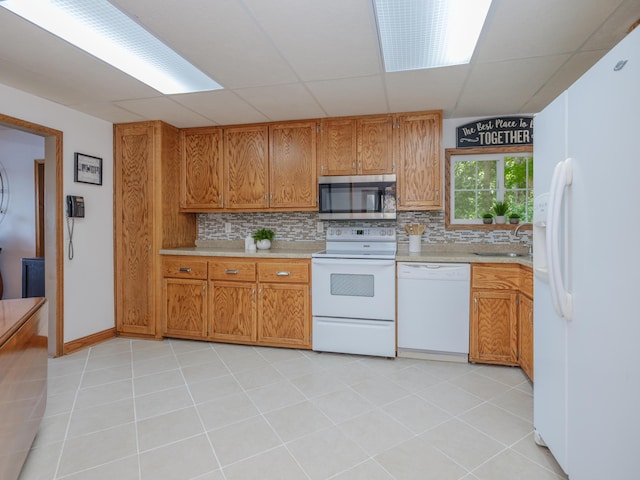 44850 Woodman Dr, Paw Paw, MI 49079 - kitchen with white appliances, tasteful backsplash, light countertops, brown cabinetry, and a paneled ceiling