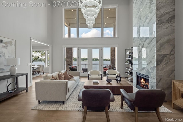 1760 Hamilton Dr, Bloomfield Hills, MI 48302 - living room with a high ceiling, a water view, a fireplace, wood finished floors, and a chandelier
