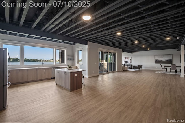 1760 Hamilton Dr, Bloomfield Hills, MI 48302 - kitchen featuring appliances with stainless steel finishes, open floor plan, a center island, a kitchen bar, and light countertops