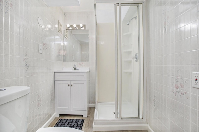 46 N 31st St, Battle Creek, MI 49015 - full bath featuring tile walls, a stall shower, vanity, and wood finished floors
