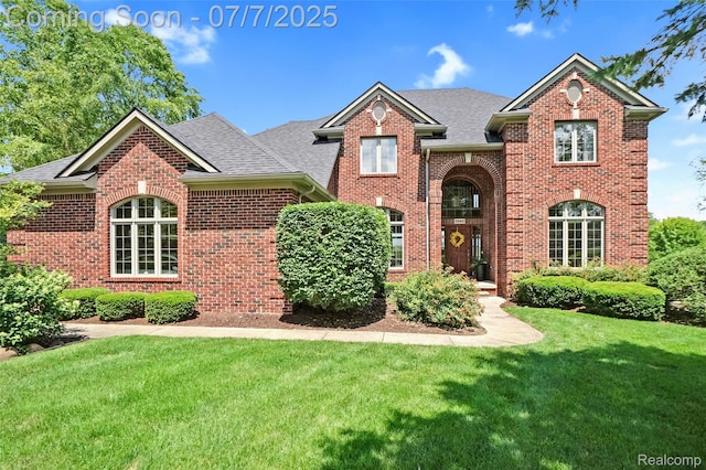 2545 Hartun Dr, Brighton, MI 48114 - traditional-style house with brick siding, a front yard, and roof with shingles