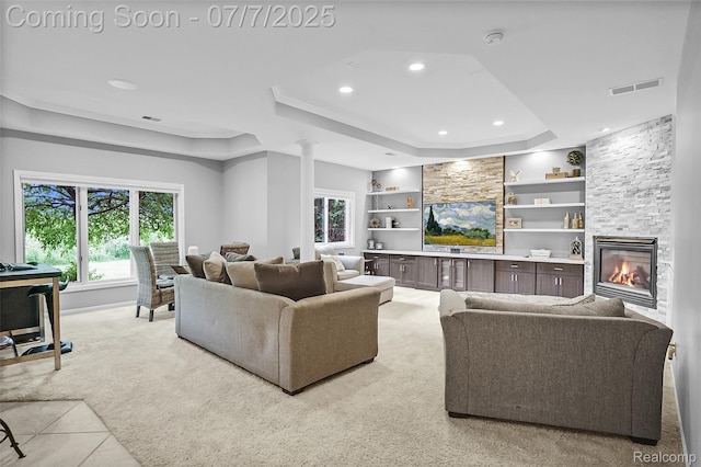 2545 Hartun Dr, Brighton, MI 48114 - living area with a raised ceiling, plenty of natural light, light colored carpet, a stone fireplace, and recessed lighting