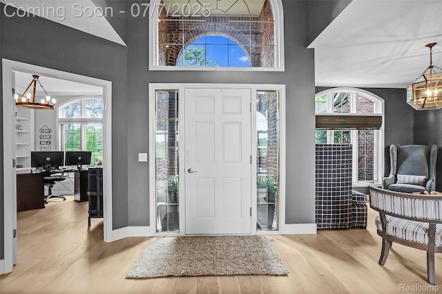 2545 Hartun Dr, Brighton, MI 48114 - foyer with a chandelier, wood finished floors, and a towering ceiling
