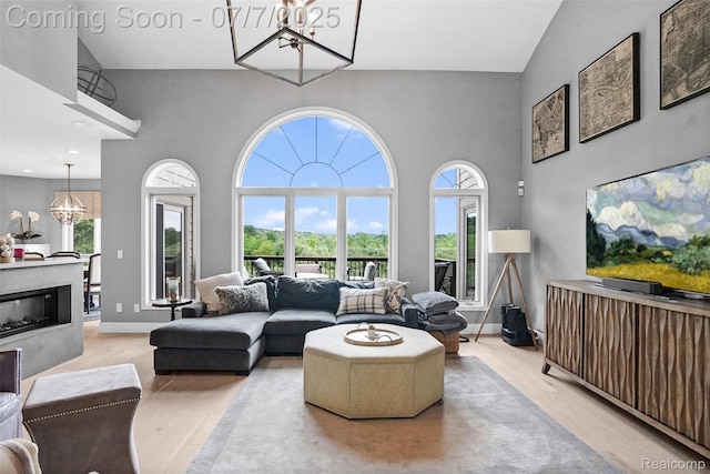 2545 Hartun Dr, Brighton, MI 48114 - living area with a chandelier, wood finished floors, a towering ceiling, and healthy amount of natural light