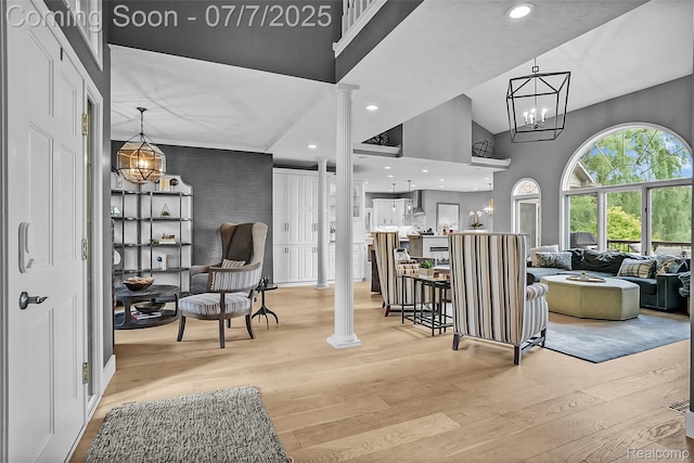 2545 Hartun Dr, Brighton, MI 48114 - entrance foyer with decorative columns, a towering ceiling, light wood-style flooring, recessed lighting, and a chandelier