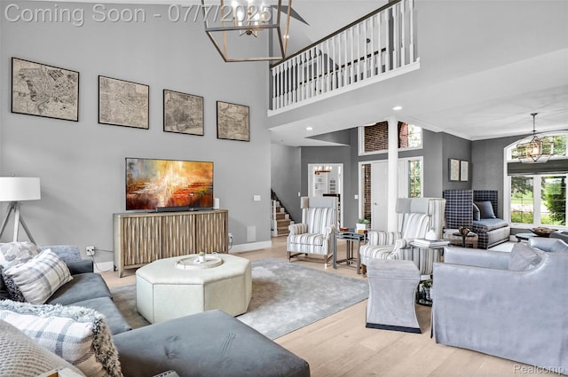 2545 Hartun Dr, Brighton, MI 48114 - living area with a chandelier, wood finished floors, stairway, and a towering ceiling