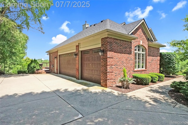 2545 Hartun Dr, Brighton, MI 48114 - view of side of property featuring concrete driveway, brick siding, an attached garage, and a chimney
