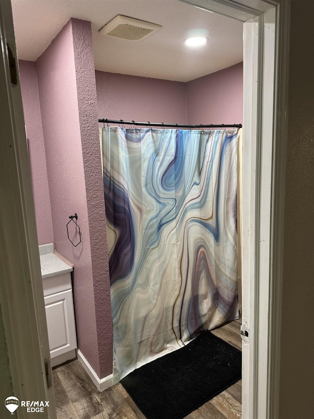 11454 Haven St, Clio, MI 48420 - full bathroom with wood finished floors, a textured wall, curtained shower, and vanity