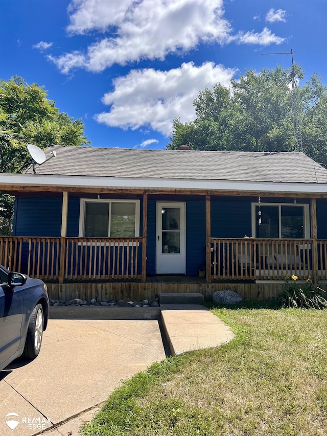 11454 Haven St, Clio, MI 48420 - view of front facade featuring covered porch, roof with shingles, and a front lawn