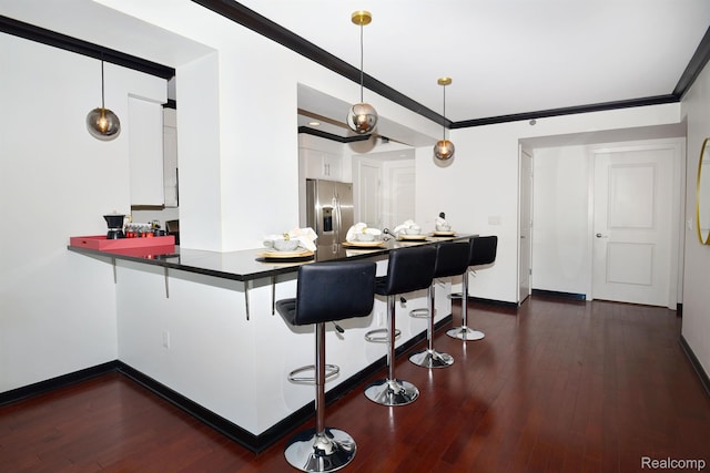 1135 Shelby St Unit 2607, Detroit, MI 48226 - kitchen featuring stainless steel fridge, a kitchen breakfast bar, white cabinetry, dark countertops, and a peninsula