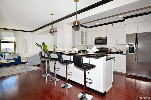 1135 Shelby St Unit 2607, Detroit, MI 48226 - kitchen with stainless steel appliances, a breakfast bar area, crown molding, dark countertops, and white cabinets