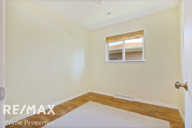 2524 Whitemore Pl, Saginaw, MI 48602 - unfurnished room with wood finished floors, a baseboard radiator, and a smoke detector