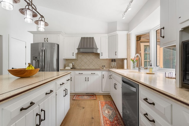 295 N Lakeshore Dr, Holland, MI 49424 - kitchen with appliances with stainless steel finishes, custom range hood, light wood-type flooring, light countertops, and decorative backsplash