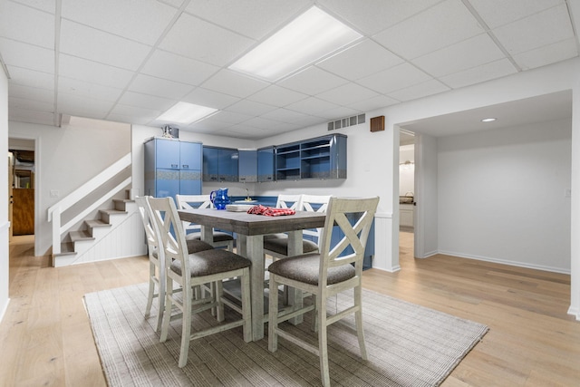 295 N Lakeshore Dr, Holland, MI 49424 - dining room featuring light wood-style flooring, stairway, and a drop ceiling