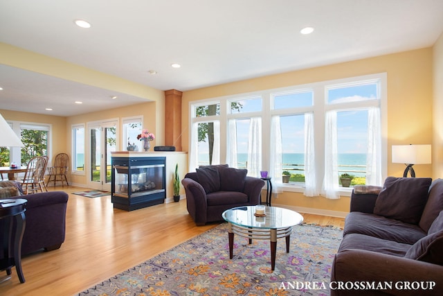 1228 Shore Crest Dr, South Haven, MI 49090 - living area featuring a multi sided fireplace, light wood-style floors, recessed lighting, and a water view