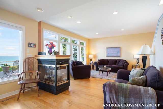 1228 Shore Crest Dr, South Haven, MI 49090 - living room featuring light wood-type flooring, a multi sided fireplace, recessed lighting, and a water view