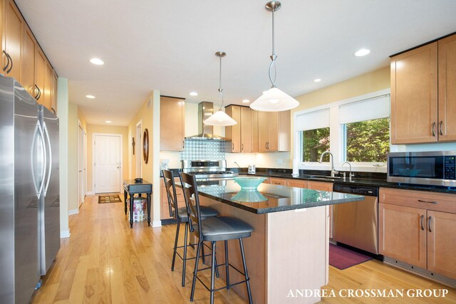 1228 Shore Crest Dr, South Haven, MI 49090 - kitchen featuring appliances with stainless steel finishes, wall chimney exhaust hood, a breakfast bar area, light wood finished floors, and recessed lighting