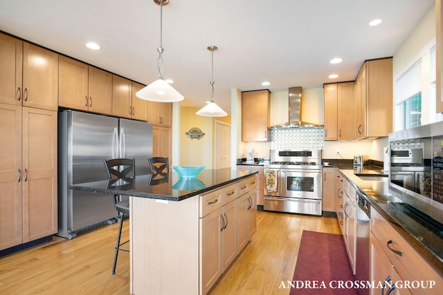 1228 Shore Crest Dr, South Haven, MI 49090 - kitchen with stainless steel appliances, wall chimney exhaust hood, light wood-style flooring, a kitchen bar, and recessed lighting