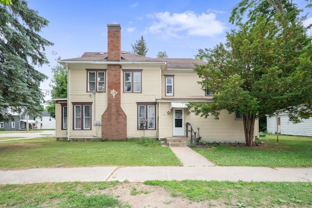 405 5th St, Evart, MI 49631 - view of front facade with a chimney and a front lawn