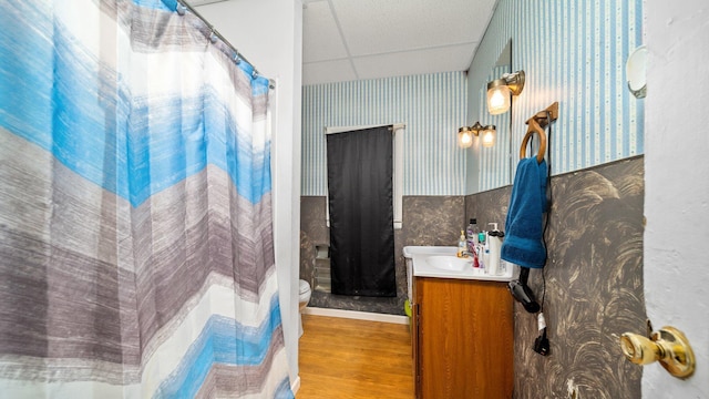 405 5th St, Evart, MI 49631 - bathroom featuring a drop ceiling, wallpapered walls, vanity, wood finished floors, and a shower with curtain