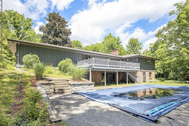 55835 Davis Ln, Dowagiac, MI 49047 - back of house with stairway, a wooden deck, a chimney, brick siding, and board and batten siding