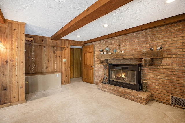 55835 Davis Ln, Dowagiac, MI 49047 - unfurnished living room with carpet floors, wooden walls, a textured ceiling, beamed ceiling, and a fireplace
