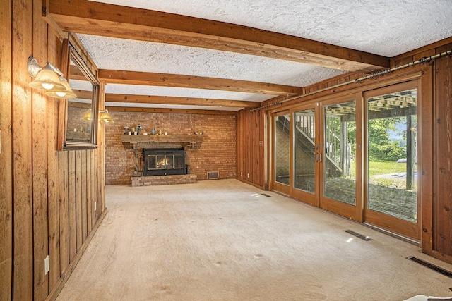 55835 Davis Ln, Dowagiac, MI 49047 - unfurnished living room with beamed ceiling, a textured ceiling, carpet floors, wooden walls, and a brick fireplace