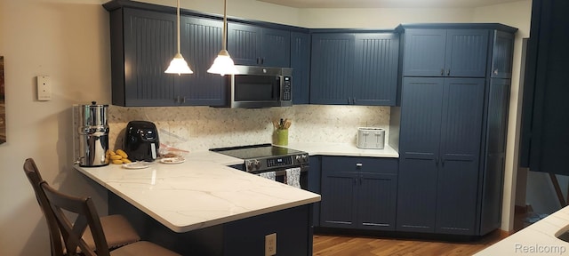 15203 Woodpine Dr, Monroe, MI 48161 - kitchen with stainless steel appliances, a peninsula, a kitchen breakfast bar, and tasteful backsplash