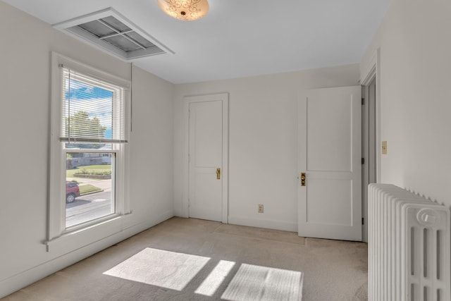 715 Ellery Ave, Jackson, MI 49202 - unfurnished bedroom featuring radiator heating unit and light colored carpet