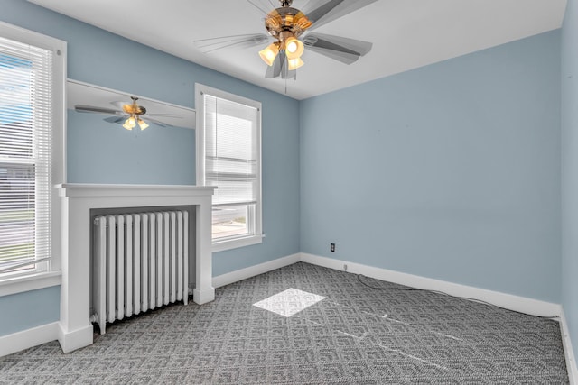 715 Ellery Ave, Jackson, MI 49202 - carpeted empty room featuring radiator heating unit, a ceiling fan, and healthy amount of natural light