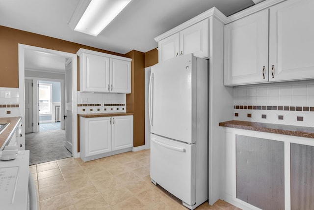 715 Ellery Ave, Jackson, MI 49202 - kitchen with freestanding refrigerator, tasteful backsplash, and white cabinets