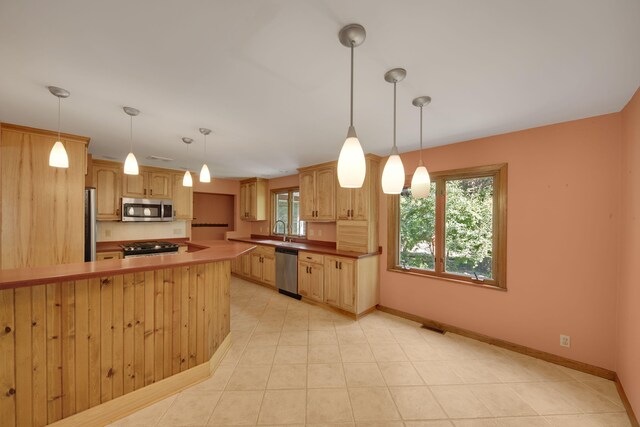 99 Tahoma Trl, New Buffalo, MI 49117 - kitchen featuring stainless steel appliances, a peninsula, decorative light fixtures, and light tile patterned floors