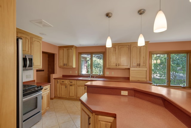 99 Tahoma Trl, New Buffalo, MI 49117 - kitchen featuring appliances with stainless steel finishes, light brown cabinets, decorative light fixtures, light tile patterned floors, and light countertops