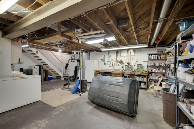 99 Tahoma Trl, New Buffalo, MI 49117 - unfinished below grade area with a workshop area, stairs, and freestanding refrigerator