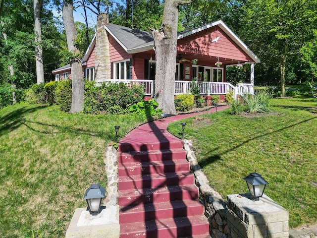 99 Tahoma Trl, New Buffalo, MI 49117 - back of property with a porch, a lawn, and a chimney